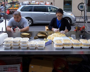 Durian and jackfruit vendor in Manhattan's Chinatown. Plastic containers with durian and jackfruit on the table (and a pile of jackfruit rags).