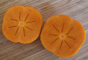 Cut fuyu persimmon, revealing empty carpels
